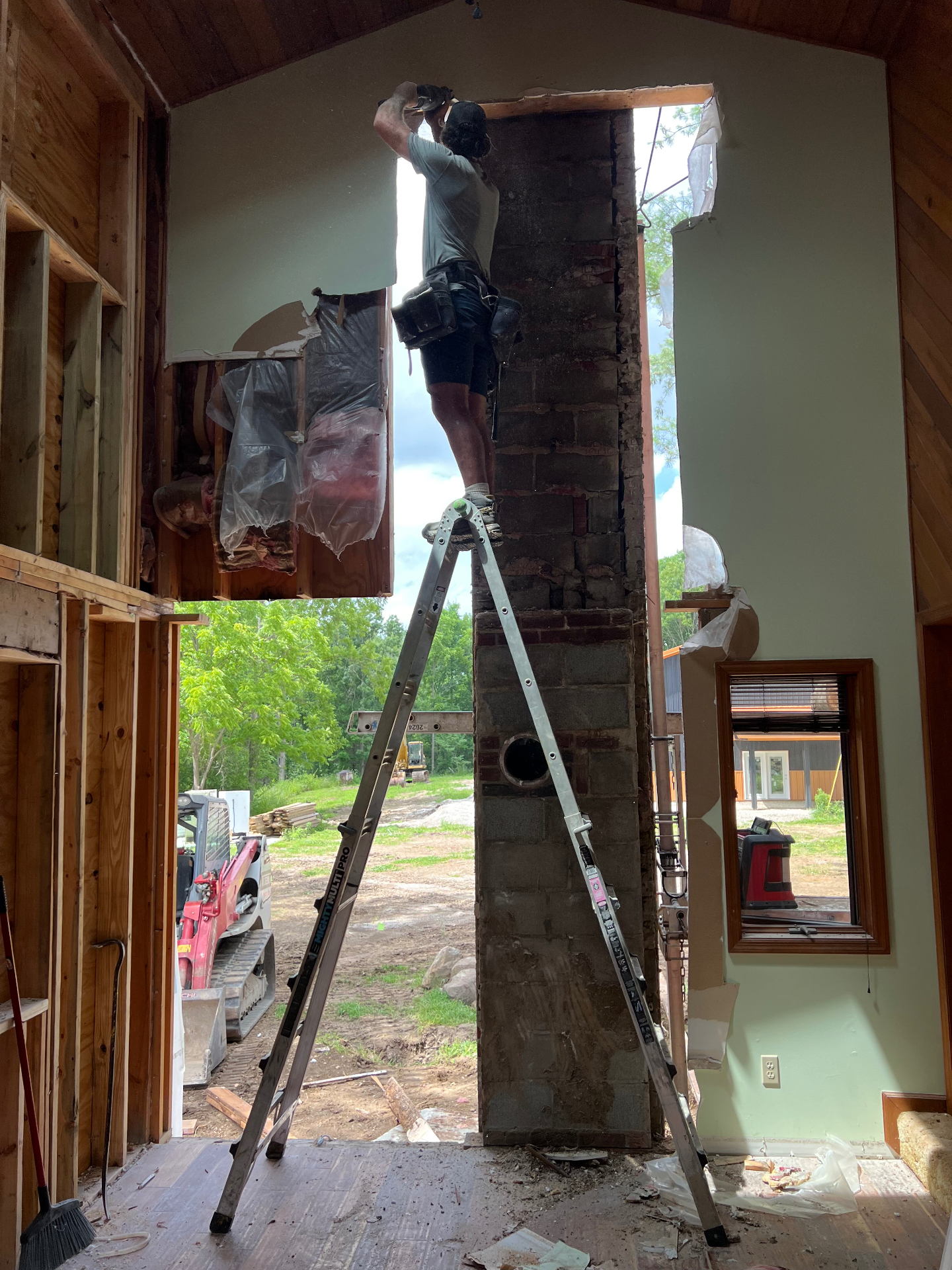 Crew removing rotted wall structure around a chimney