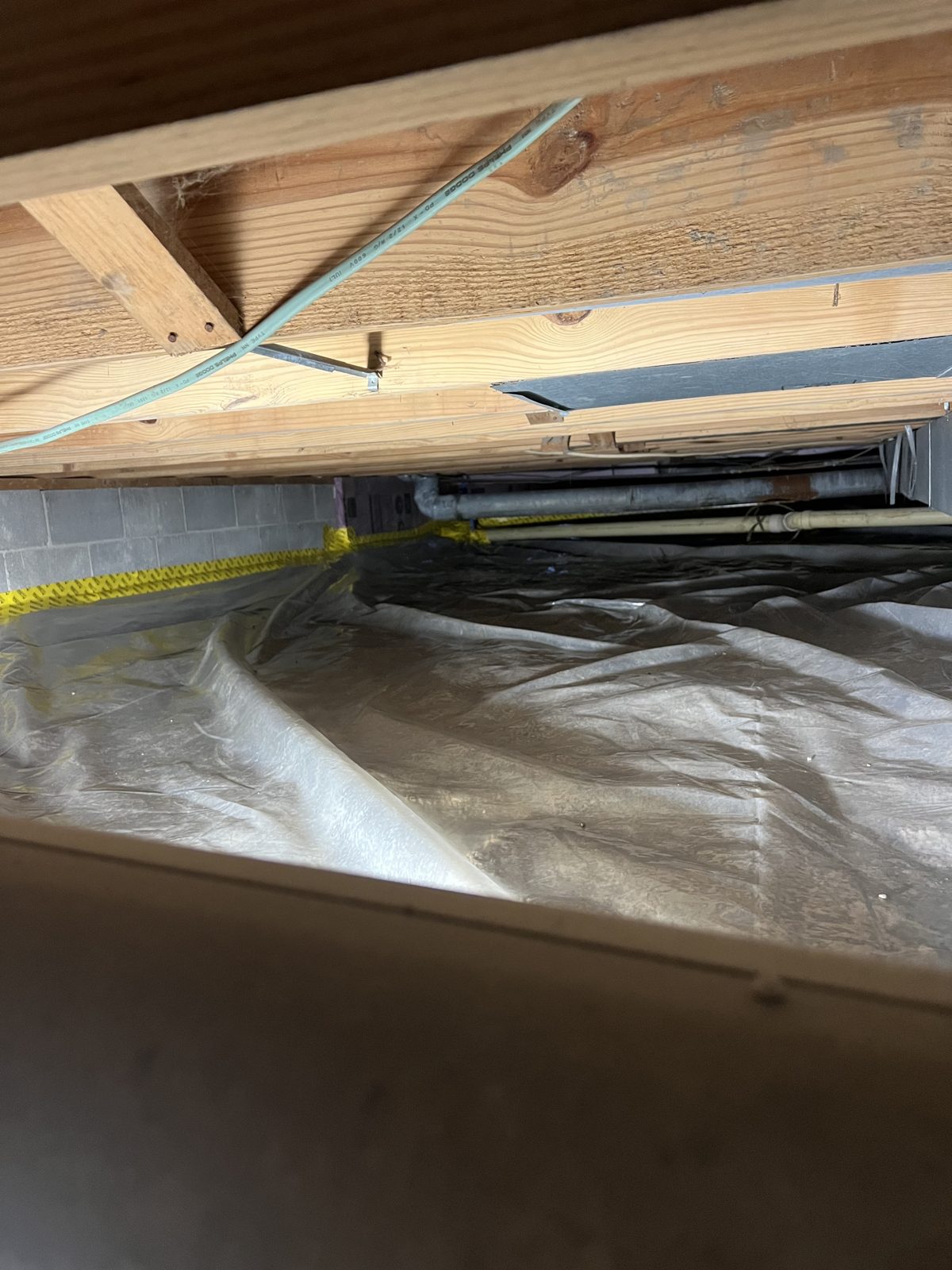 Crawl space vapor barrier installation in progress